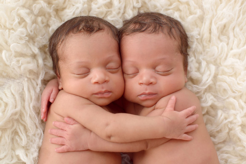 postpartum photography showing two babies holding each other